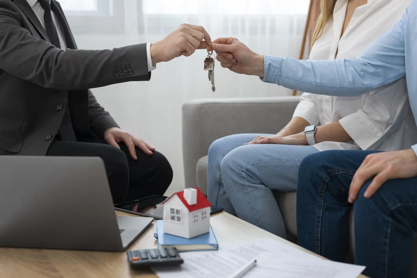 Asesor entregando las llaves de una casa a una pareja